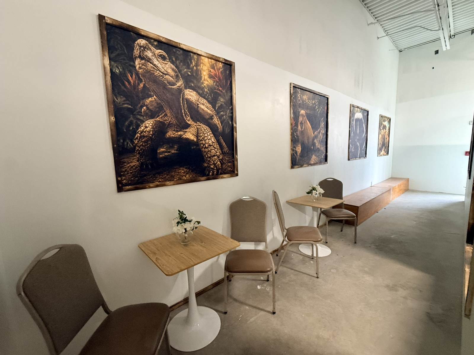 Cafe tables beneath framed wood-burned animal artwork